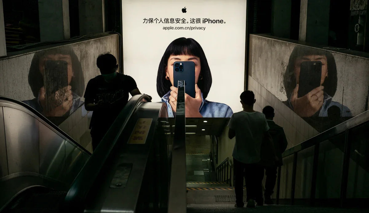 Yeraltı geçidinde Apple iPhone reklamı, yürüyen merdivende insanlar, büyük bilboard