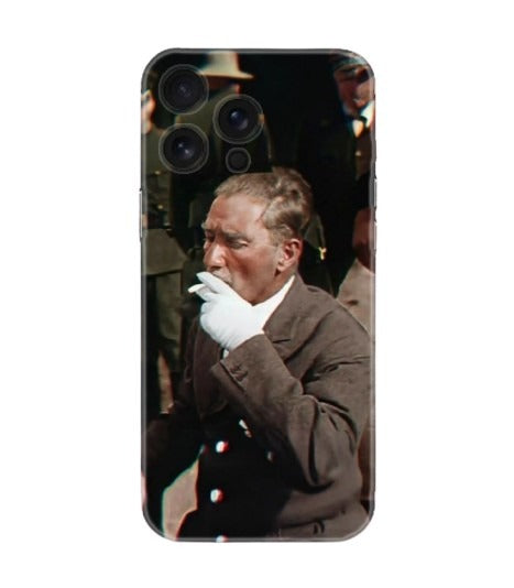 Kahverengi ceketli, eldivenli adam figürlü telefon kılıfı, arka planda insanlar var.